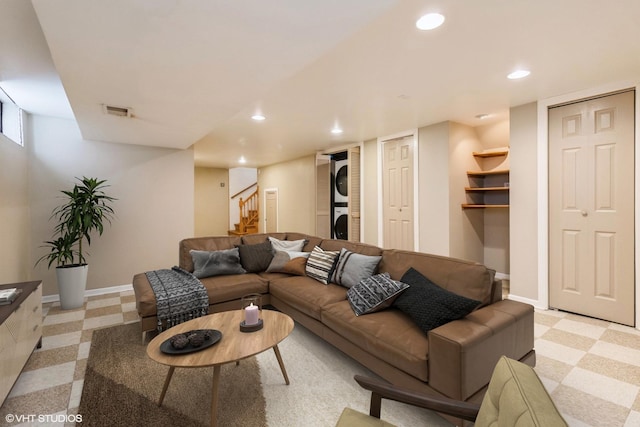 living area featuring stacked washing maching and dryer, baseboards, stairway, and recessed lighting