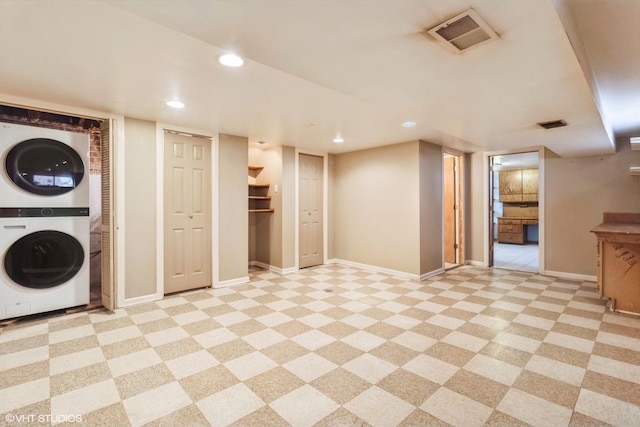 finished basement with stacked washing maching and dryer, baseboards, visible vents, and recessed lighting