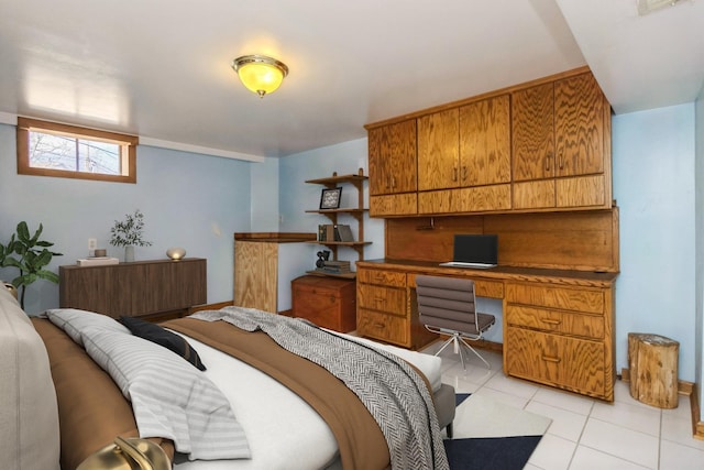 bedroom featuring built in study area and light tile patterned floors