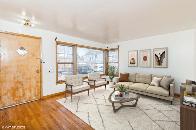 unfurnished living room featuring light wood finished floors and baseboards