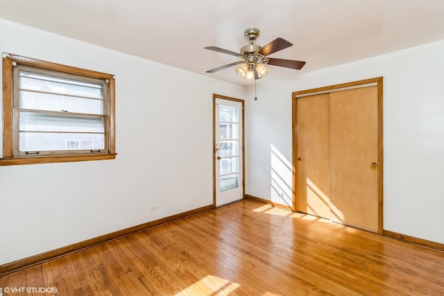 unfurnished bedroom featuring light wood-type flooring, a closet, ceiling fan, and baseboards