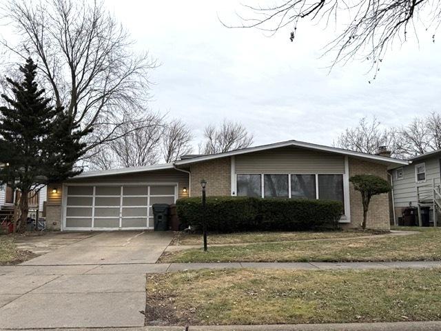 ranch-style house with a front yard and a garage