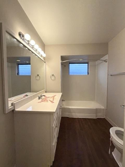 full bathroom with shower / washtub combination, vanity, wood-type flooring, and toilet