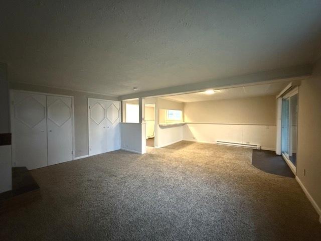 carpeted spare room with baseboard heating