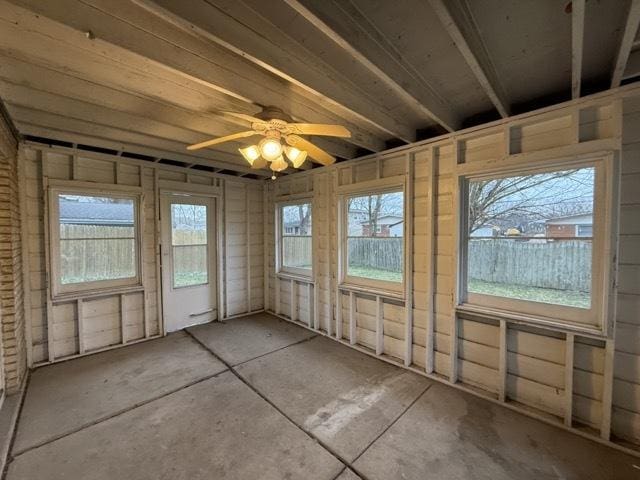 unfurnished sunroom with ceiling fan