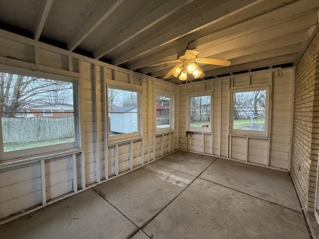 unfurnished sunroom featuring ceiling fan