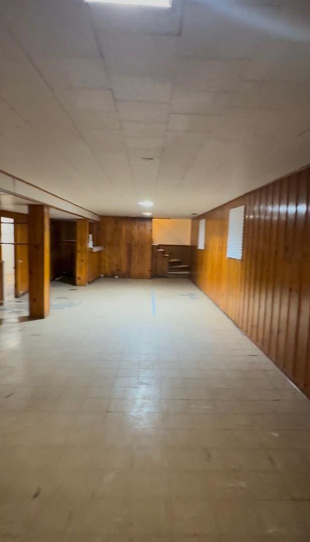 basement featuring wooden walls