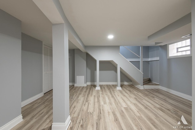 basement with light hardwood / wood-style floors