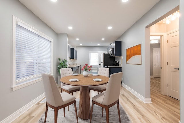 dining room featuring sink and light hardwood / wood-style floors