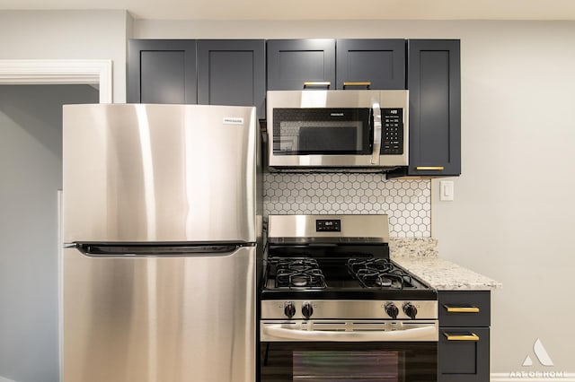 kitchen featuring light stone countertops, decorative backsplash, and stainless steel appliances