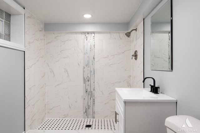 bathroom featuring vanity, toilet, and a tile shower