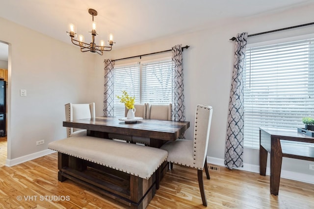 dining space featuring an inviting chandelier and light wood-type flooring