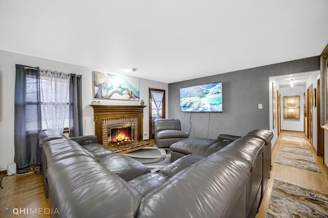 living room with light wood-type flooring and a fireplace