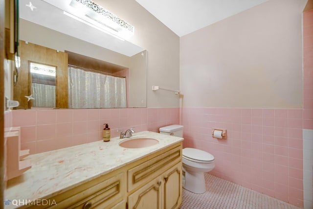 bathroom with vanity, tile patterned floors, toilet, tile walls, and curtained shower