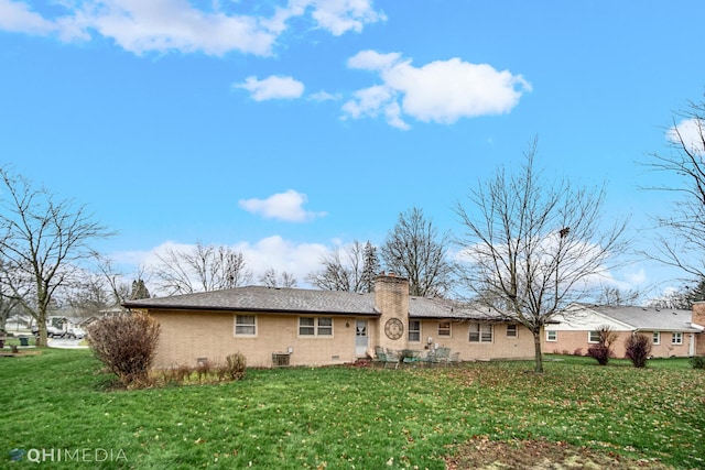 rear view of property with a yard