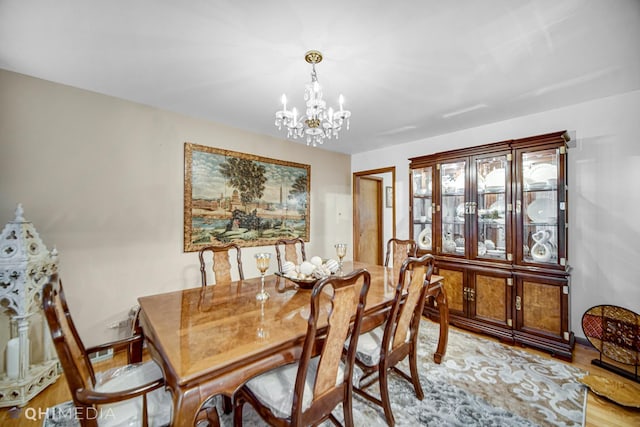 dining space featuring light hardwood / wood-style floors and a notable chandelier