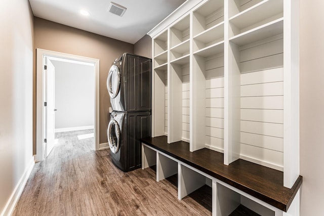 mudroom featuring stacked washer and dryer and hardwood / wood-style flooring