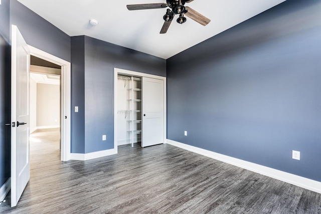 unfurnished bedroom with a closet, ceiling fan, and dark hardwood / wood-style flooring