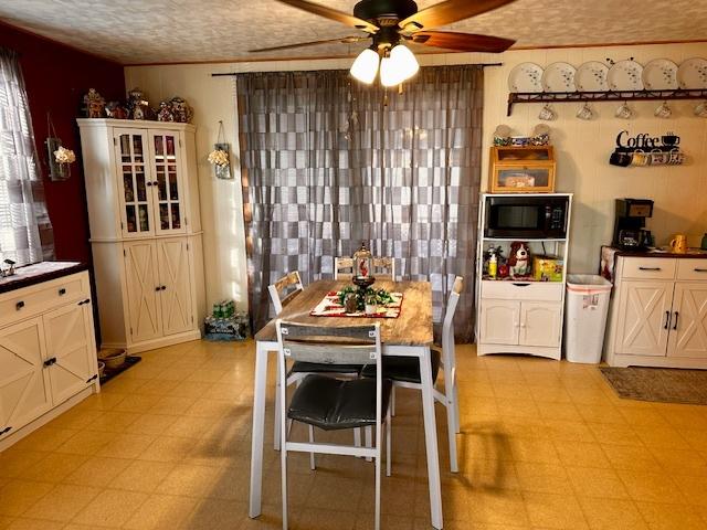 dining room with ceiling fan and a textured ceiling