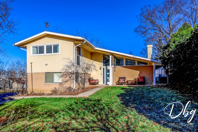 rear view of property with a lawn