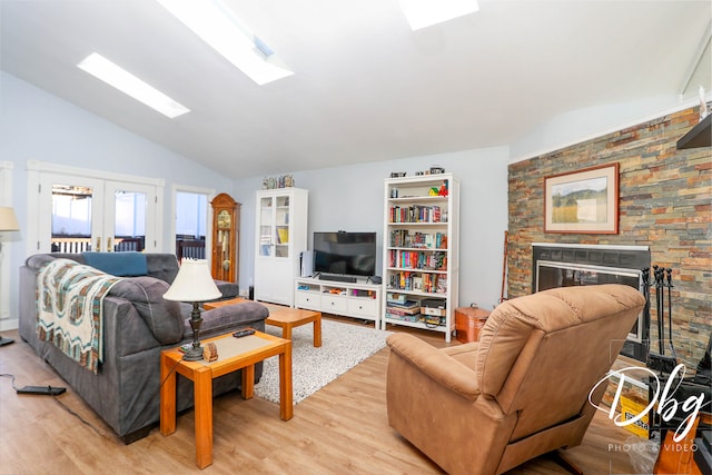 living room with light hardwood / wood-style flooring, french doors, and lofted ceiling with skylight