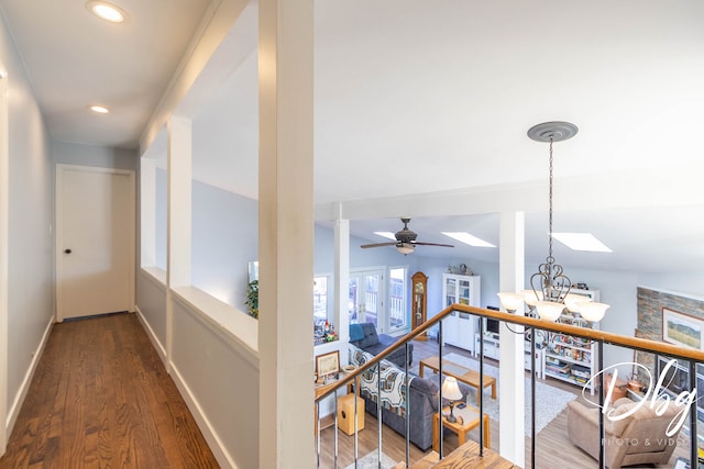 hall with lofted ceiling, an inviting chandelier, and hardwood / wood-style flooring