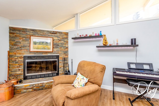 sitting room featuring a stone fireplace and wood-type flooring