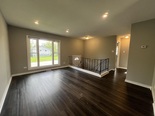 empty room with dark hardwood / wood-style flooring