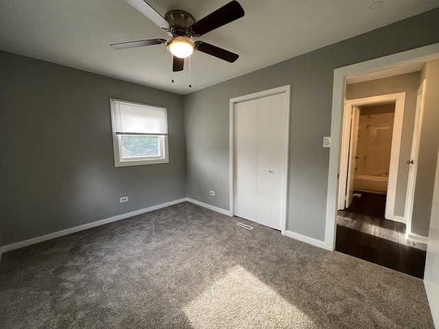 unfurnished bedroom featuring dark carpet and ceiling fan