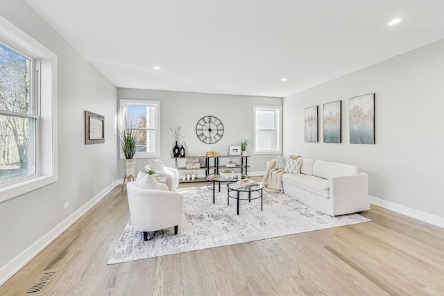 living room with a wealth of natural light and light hardwood / wood-style flooring