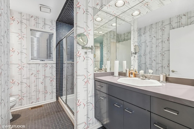 bathroom featuring tile patterned floors, vanity, toilet, and an enclosed shower