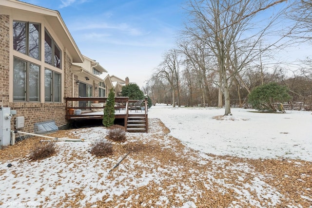 yard covered in snow with a wooden deck