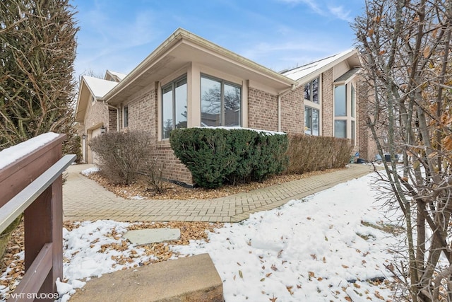 view of snow covered exterior featuring a garage