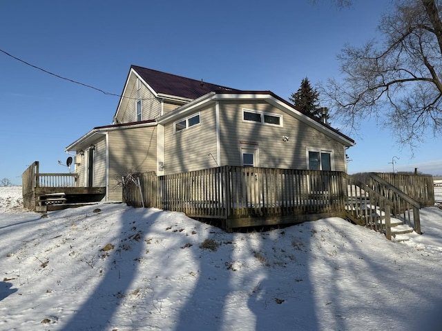 snow covered property featuring a deck