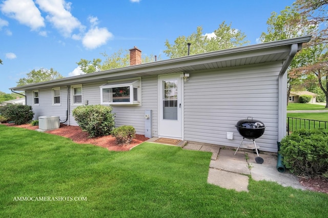 1607 Warwick Ln, Schaumburg, IL 60193 - back of property featuring central AC unit, a lawn, and a chimney