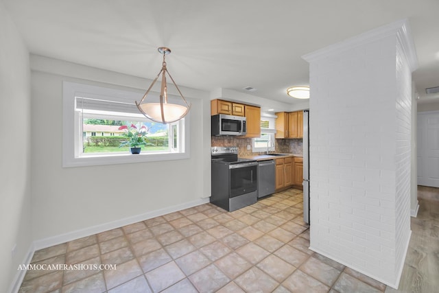 1607 Warwick Ln, Schaumburg, IL 60193 - kitchen featuring stainless steel appliances, a sink, baseboards, tasteful backsplash, and pendant lighting
