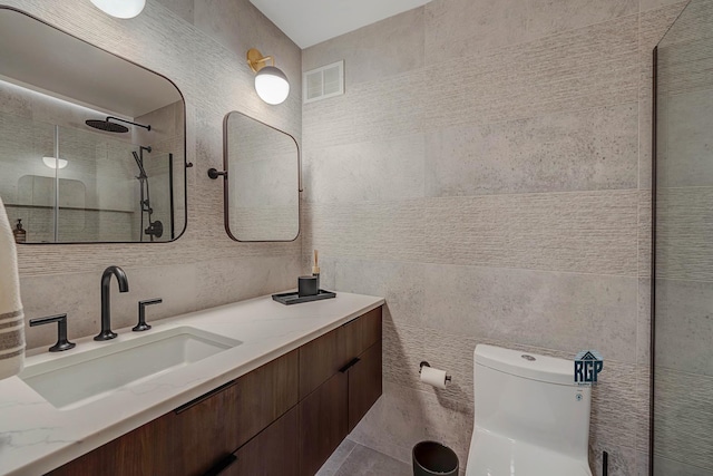 bathroom featuring tasteful backsplash, vanity, a shower, tile walls, and toilet