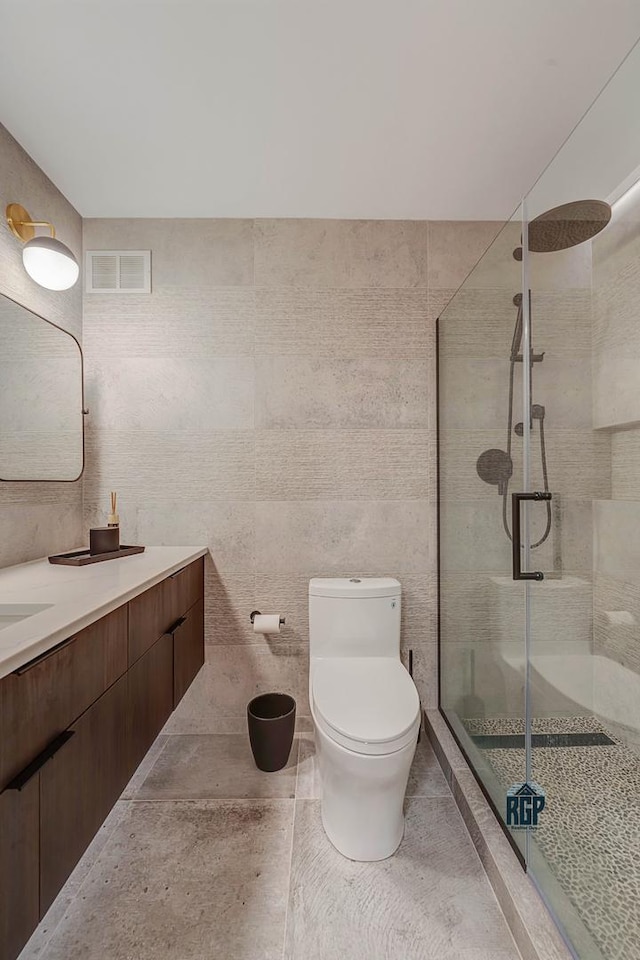 bathroom with walk in shower, vanity, tile walls, and toilet