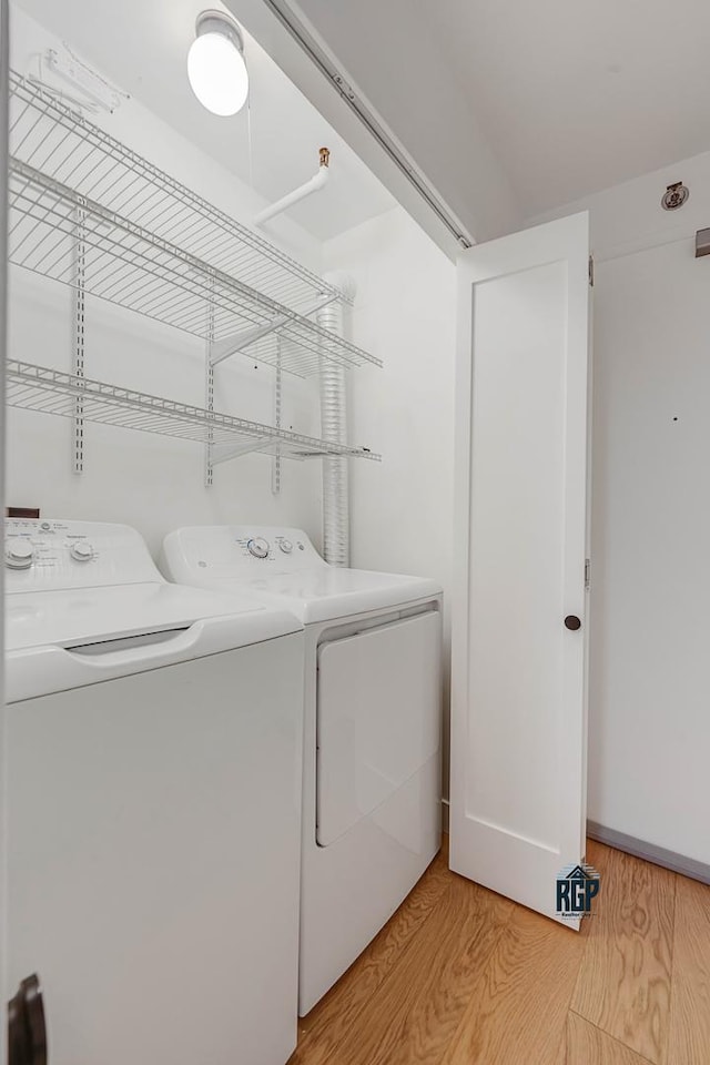 clothes washing area featuring washer and dryer and light wood-type flooring