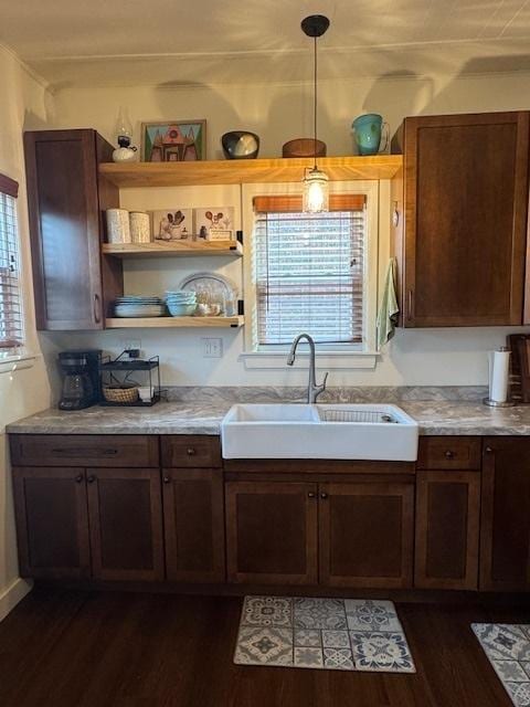 kitchen featuring dark hardwood / wood-style flooring, sink, and pendant lighting