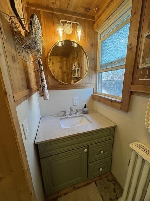 bathroom with wood walls, radiator heating unit, and vanity