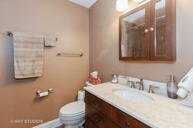 bathroom featuring vanity, toilet, and walk in shower