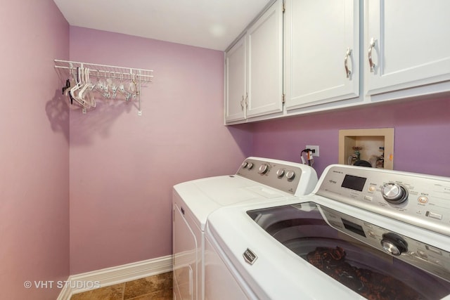 washroom featuring cabinets, washer and dryer, and dark tile patterned flooring