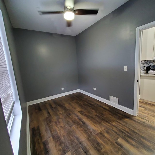 empty room featuring dark hardwood / wood-style flooring and ceiling fan