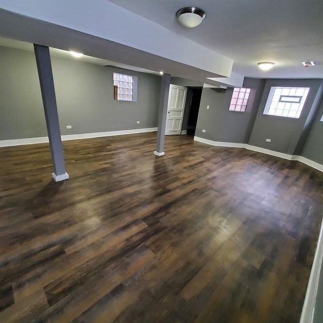 basement featuring a wealth of natural light and dark hardwood / wood-style floors