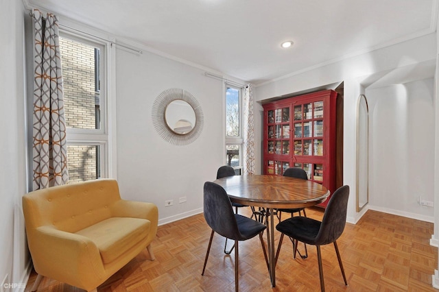 dining area with crown molding and light parquet flooring