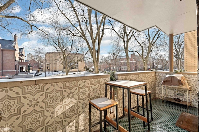 snow covered back of property with grilling area