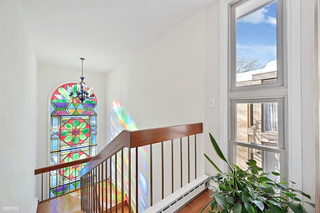 staircase featuring hardwood / wood-style flooring and a notable chandelier