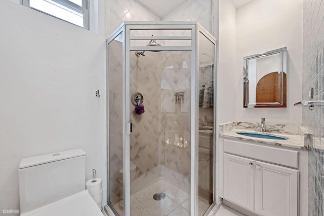 bathroom featuring vanity, an enclosed shower, and toilet