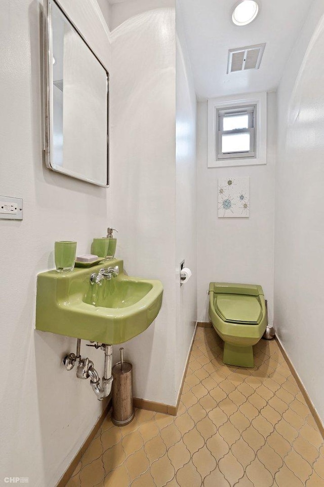 bathroom with sink, toilet, and tile patterned flooring